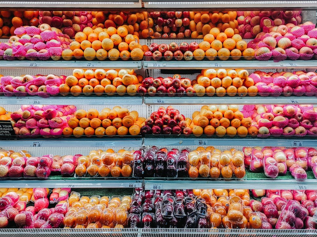 Colorful variety of fresh fruits neatly arranged on supermarket shelves, showcasing abundance and freshness.